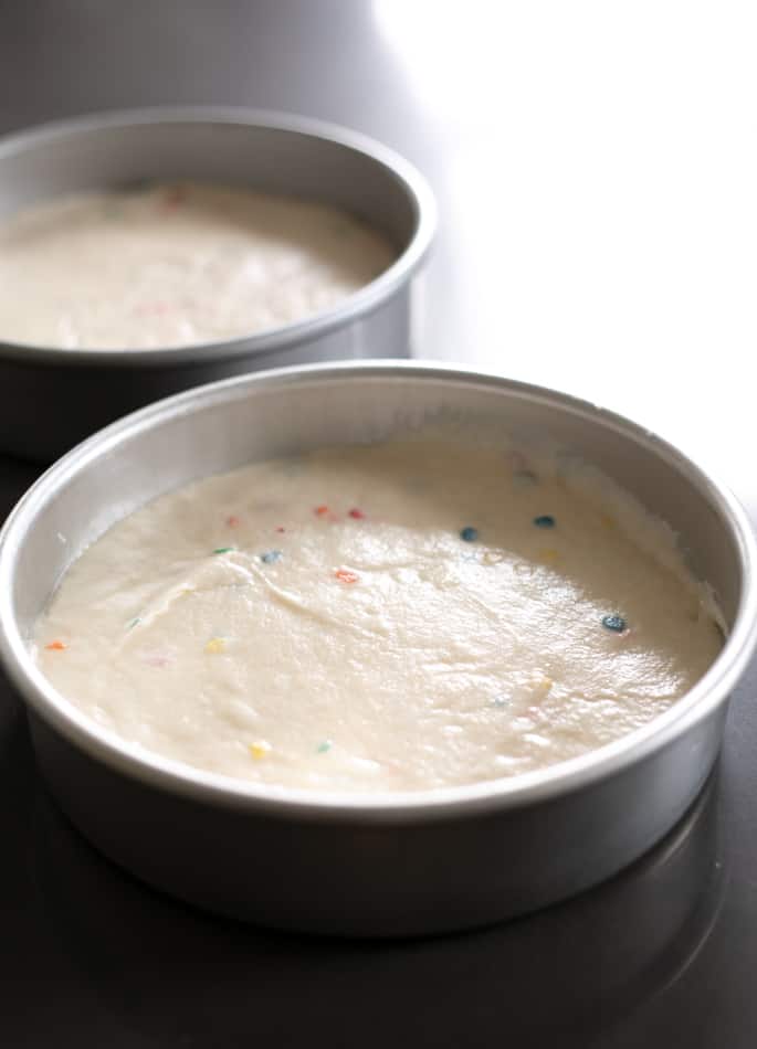 Dieser klassische glutenfreie Geburtstagskuchen ist ein Funfetti-Vanille-Schichtkuchen, gefüllt mit Schokoladen-Sauerrahm-Glasur und gekrönt mit Schokoladenglasur. 