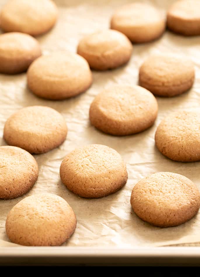 Brown gluten free nilla wafers on brown parchment paper on a tray