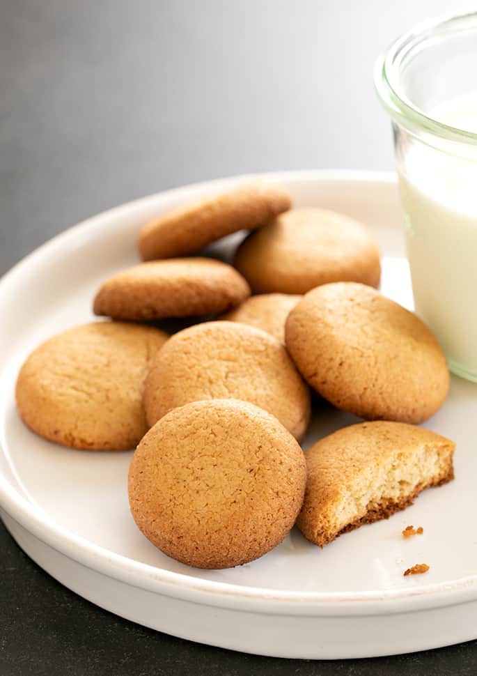 gluten free vanilla wafers on a platter served with milk and a broken cookie