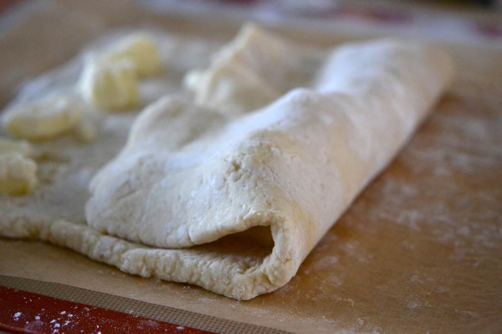 Dough being folded on brown surface 