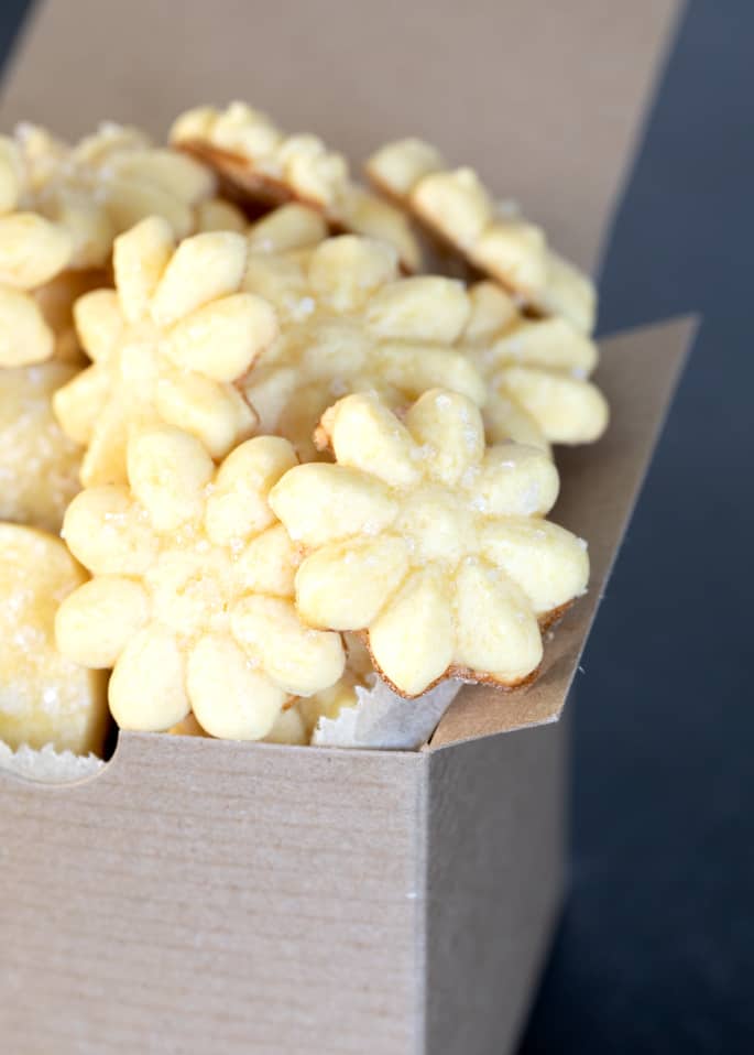 A close up of a box of gluten free butter cookies in a flower shape.