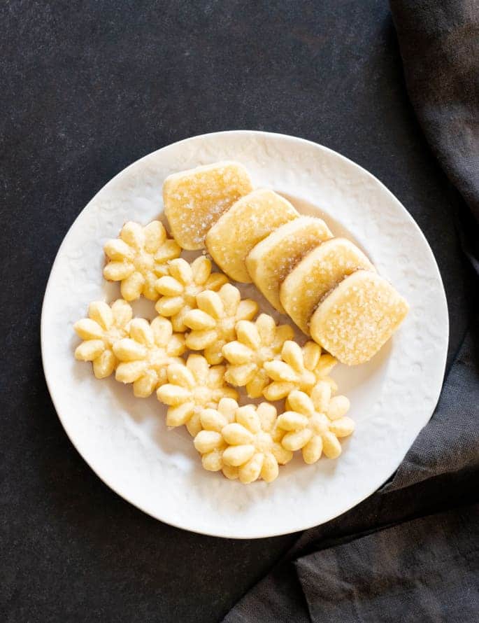 Different shapes of gluten free butter cookies on a serving plate.