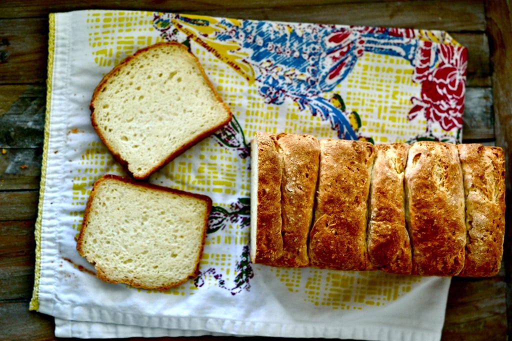 Overhead image of bread with two pieces sliced on a patterned towel