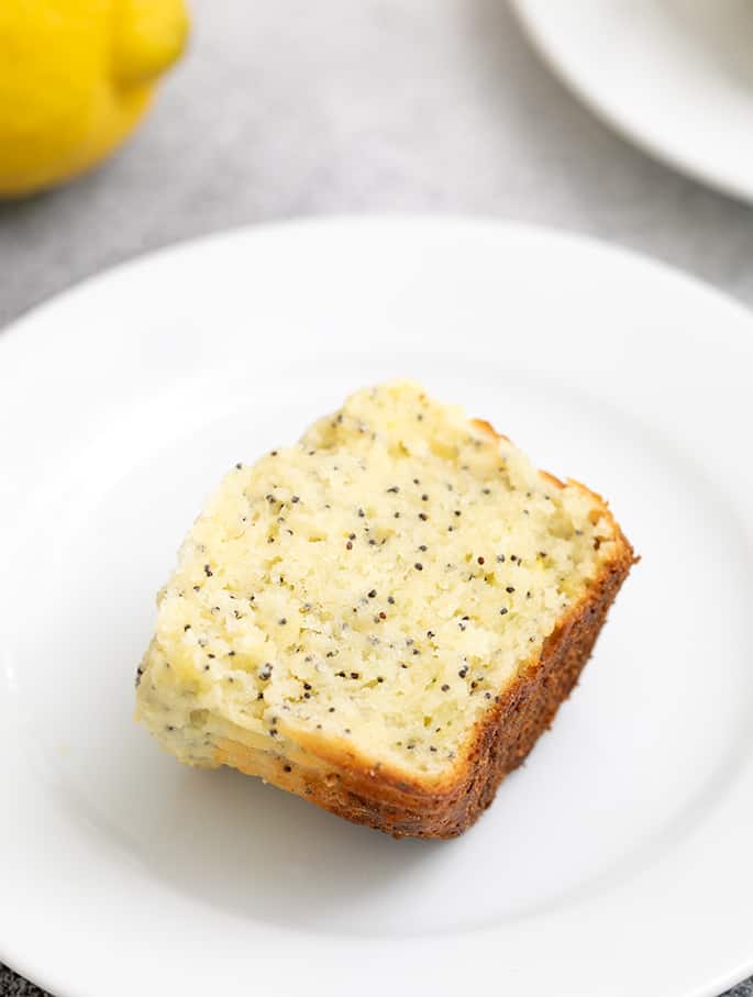 Lemon Poppyseed muffin cut in half on small white plate