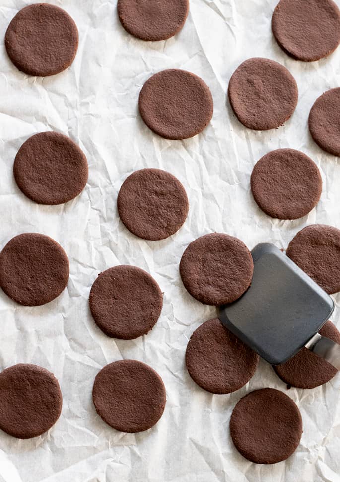 Baked gluten free thin mints cookies being taken off tray.