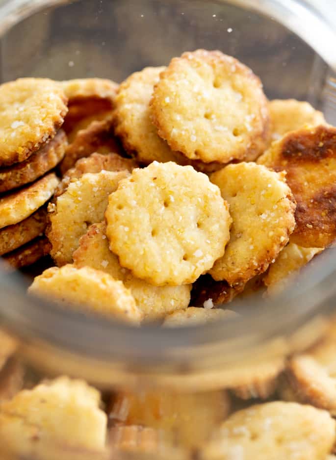 A close up of a glass jar of gluten free Parmesan crackers