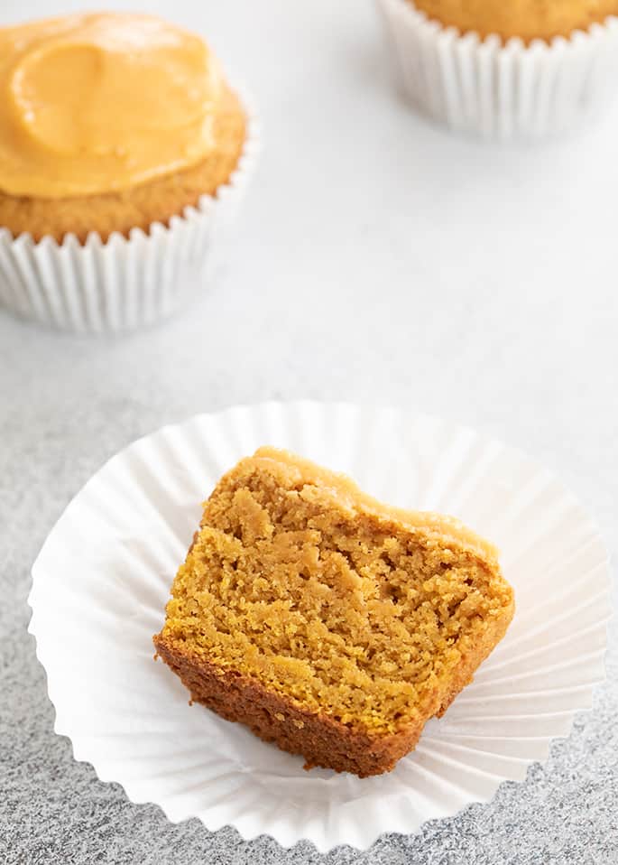 Pumpkin cupcake with icing cut in half