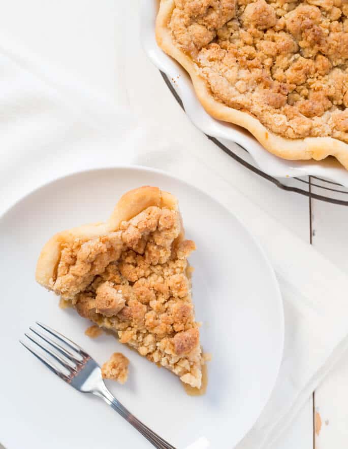 Overhead view of dutch apple pie on white plate with fork 