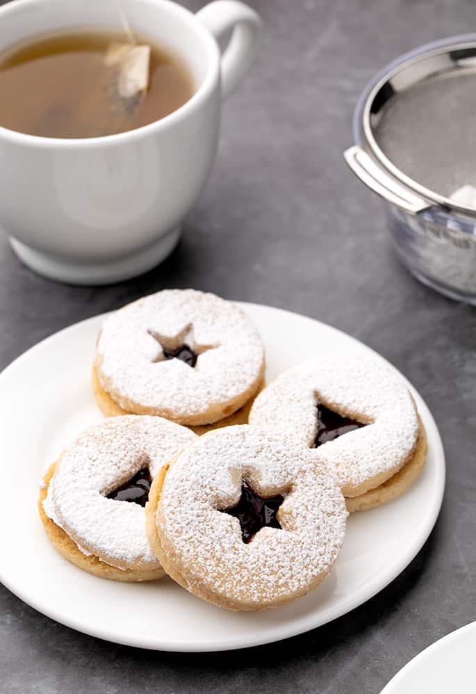 4 Linzer cookies on a small white plate