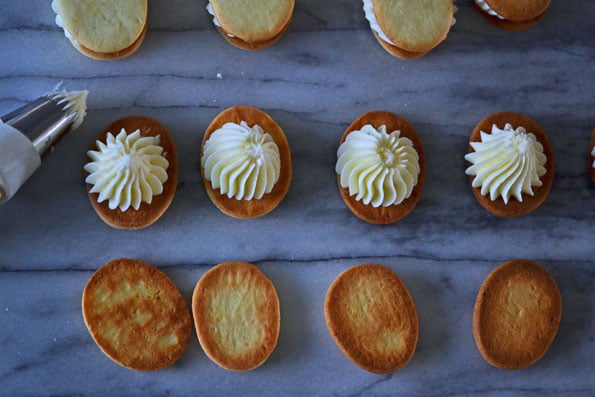 Vanilla Wafer Sandwich Cookies being frosted 