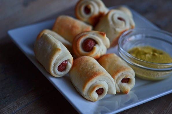 A close up of pigs in a blanket on white plate