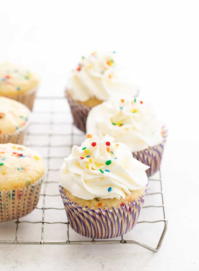 Gluten free funfetti cupcakes frosted on a wire rack