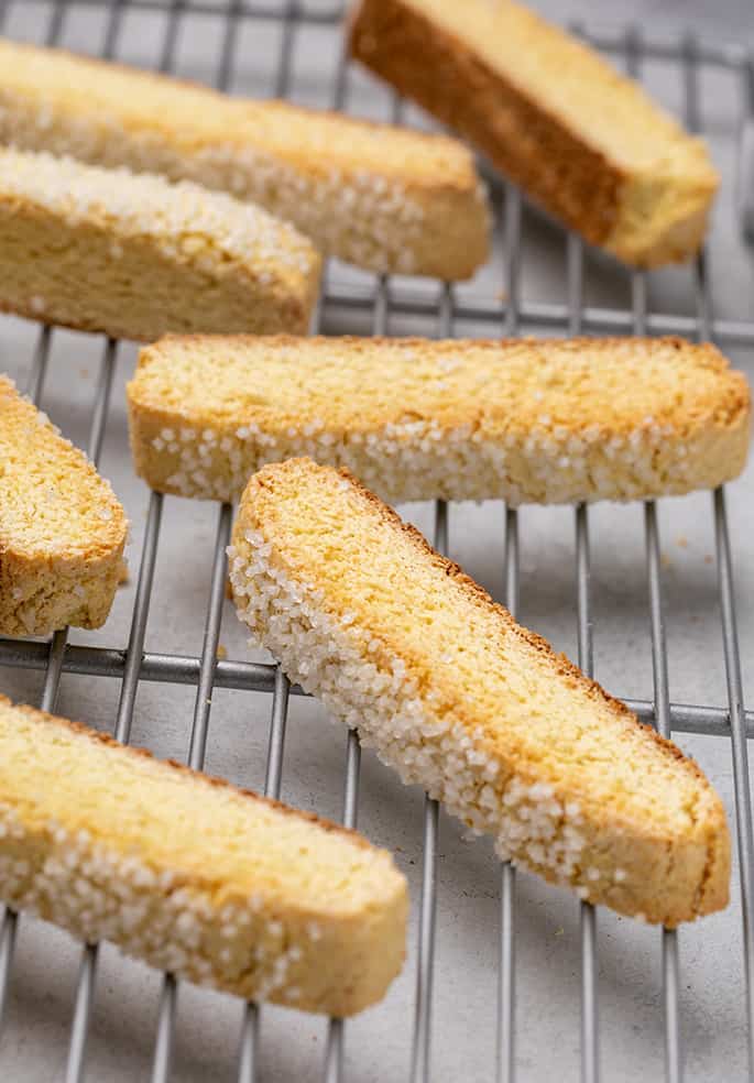 Vanilla biscotti with coarse sugar piled on wire rack