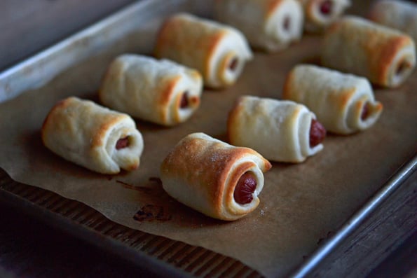 2 rows of pigs in a blanket on beige paper