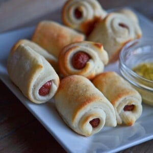 5 gluten free pigs in a blanket on white serving plate