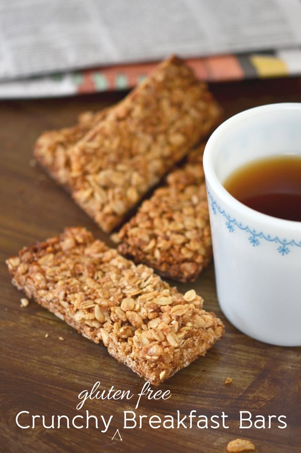 3 breakfast bars next to mug of tea on wooden surface 