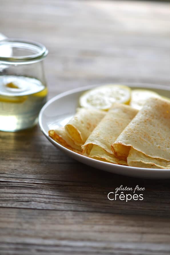 white plate with 4 folded crepes and lemon slices