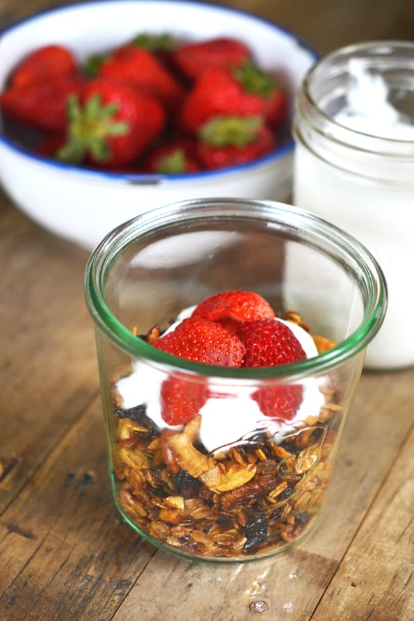 Granola, whip cream and strawberries on wooden surface 