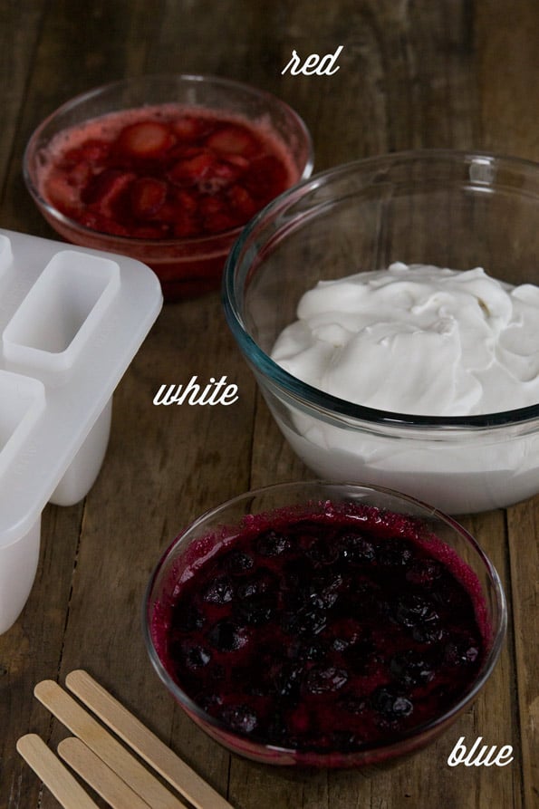 Bowls of jam and yogurt on wooden table 