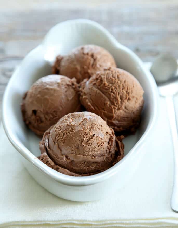 A close up of 4 scoops of ice cream in a white bowl