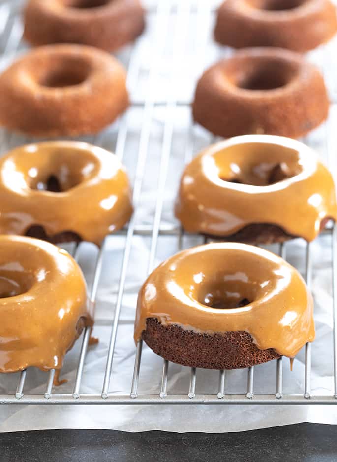 Glazed Paleo donuts sitting on top of a metal rack