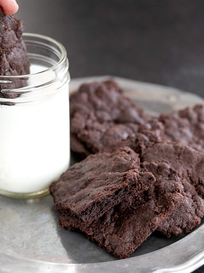 Gluten free brownie crisps being dipped in milk