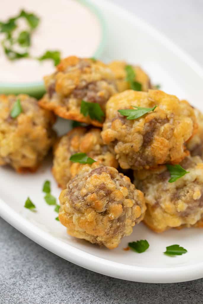 Pile of baked sausage balls on white oval platter