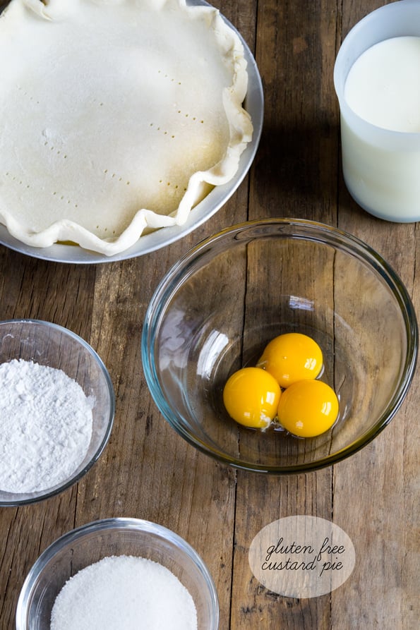 Overhead view of bowls with ingredients for pie on wooden surface