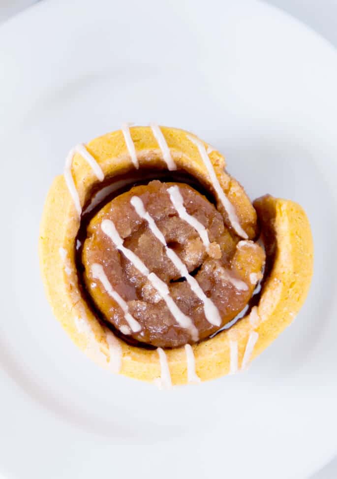 Overhead view of pumpkin cinnamon roll on white plate 