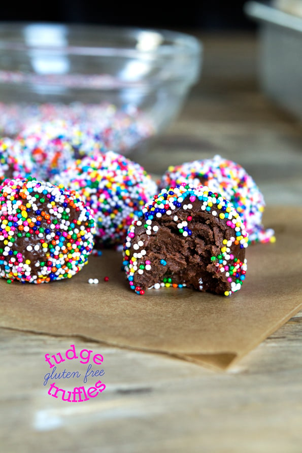 A close up image of fudge truffles from the side, one with a bite taken