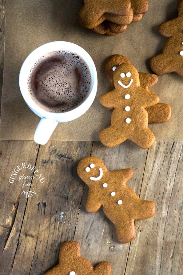 Overhead view of gingerbread men and hot chocolate on wooden surface