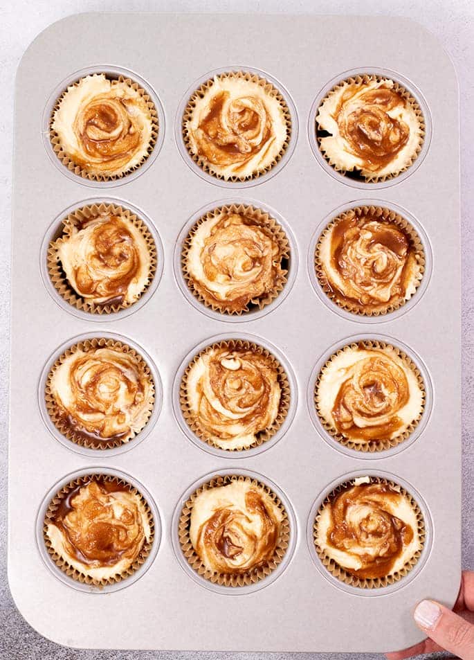 Overhead image of raw cinnamon roll cupcake batter in muffin tin