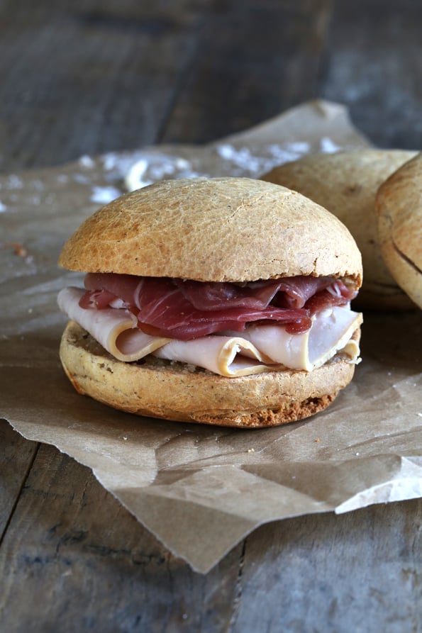 A paleo roll with lunch meat on brown surface 