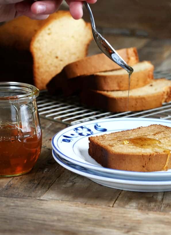 slice of light brown q2uick bread with honey on it on stack of 2 small white plates