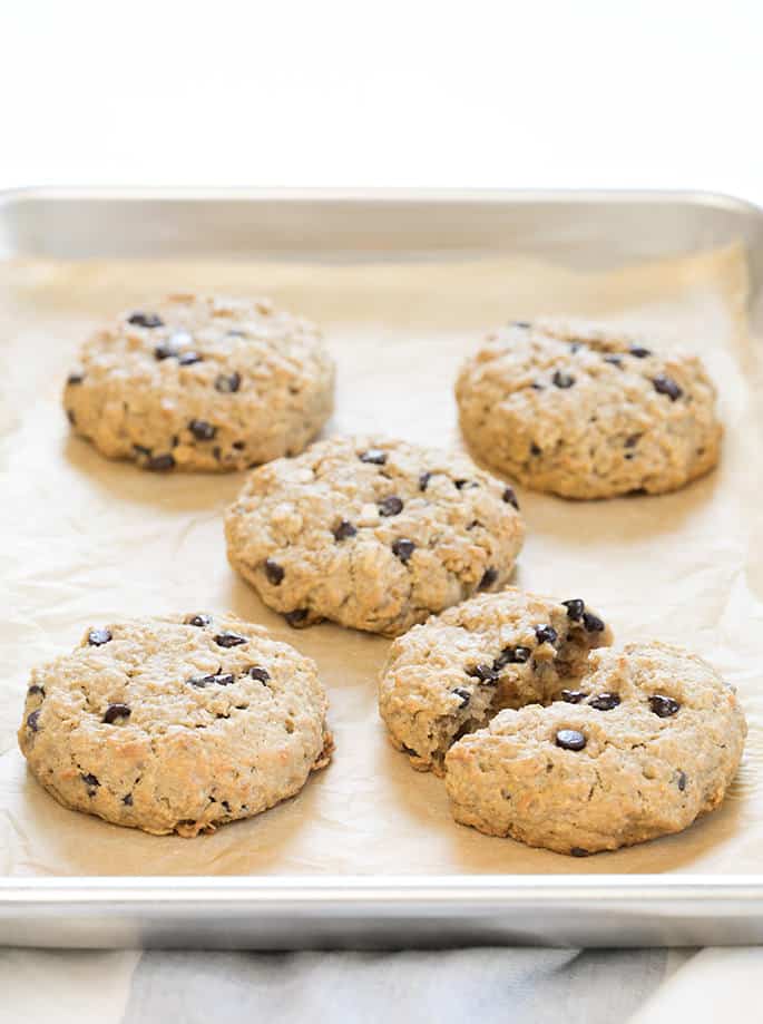 Oatmeal breakfast cookies baked on a tray, one cookie broken in half