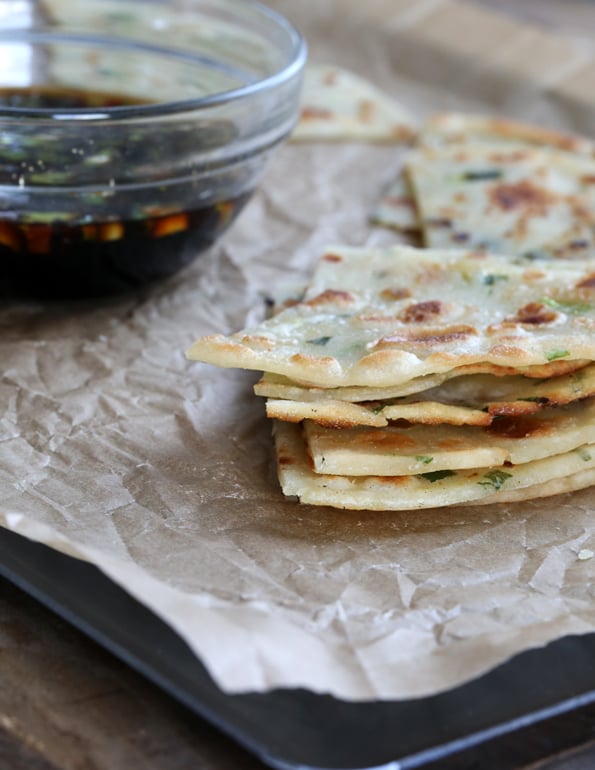 Stack of scallion pancakes on brown surface 