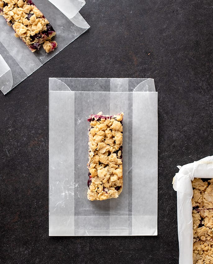 Overhead image of two bars on wax paper bags on black surface