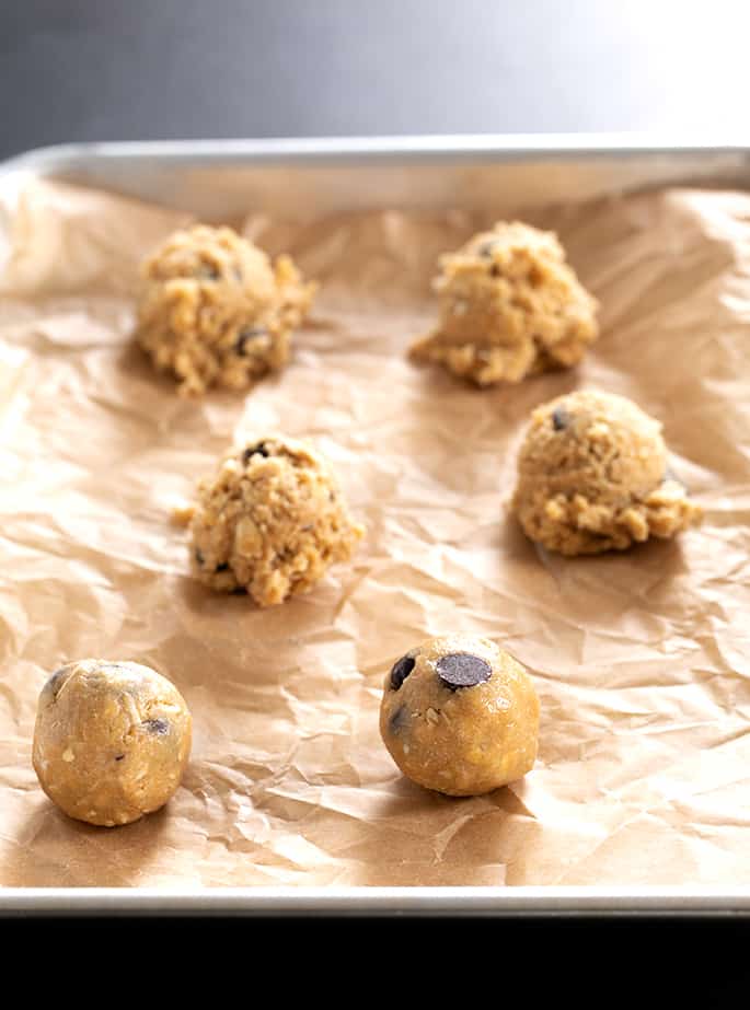 Raw peanut butter oatmeal chocolate chip cookies on a tray in balls