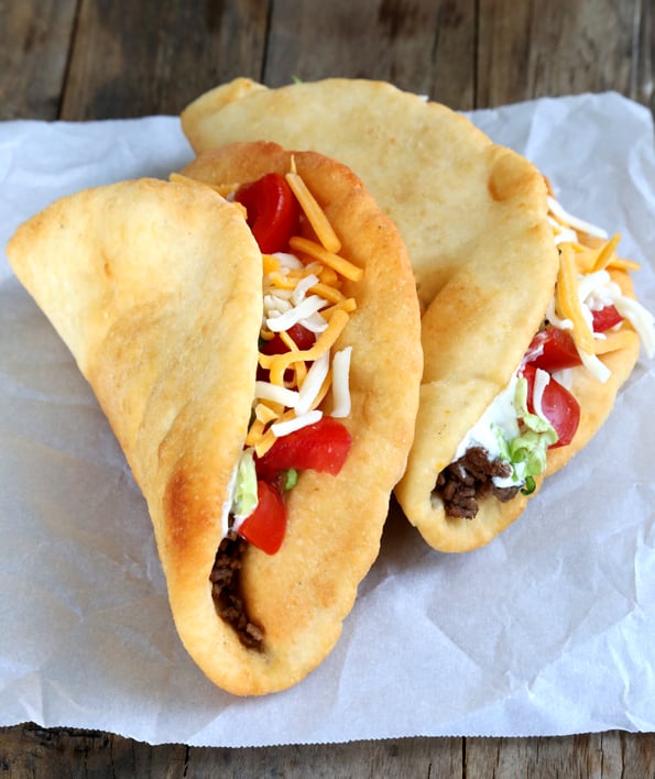 Gluten Free Chalupasโa Taco Bell copycat recipe! Tacos leaning against each other on white surface