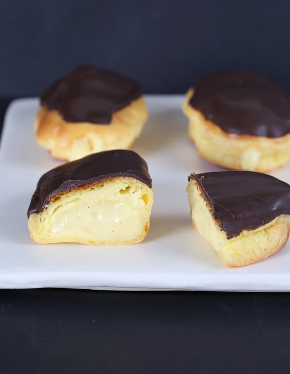 A close up of inside a chocolate eclair on white plate