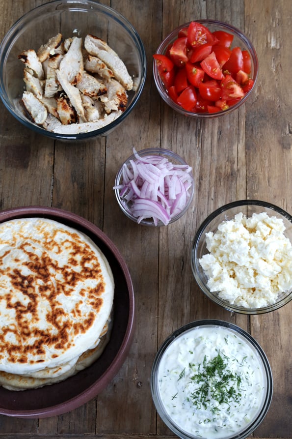 Overhead view of naan and toppings on wooden surface 