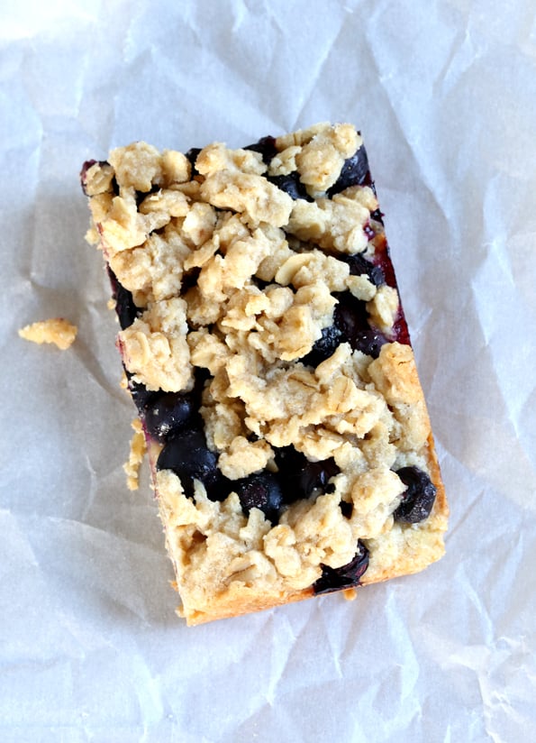 Close up of a blueberry oat bar on white surface 