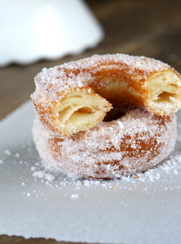 A close up of a stack of 2 donuts on white surface 