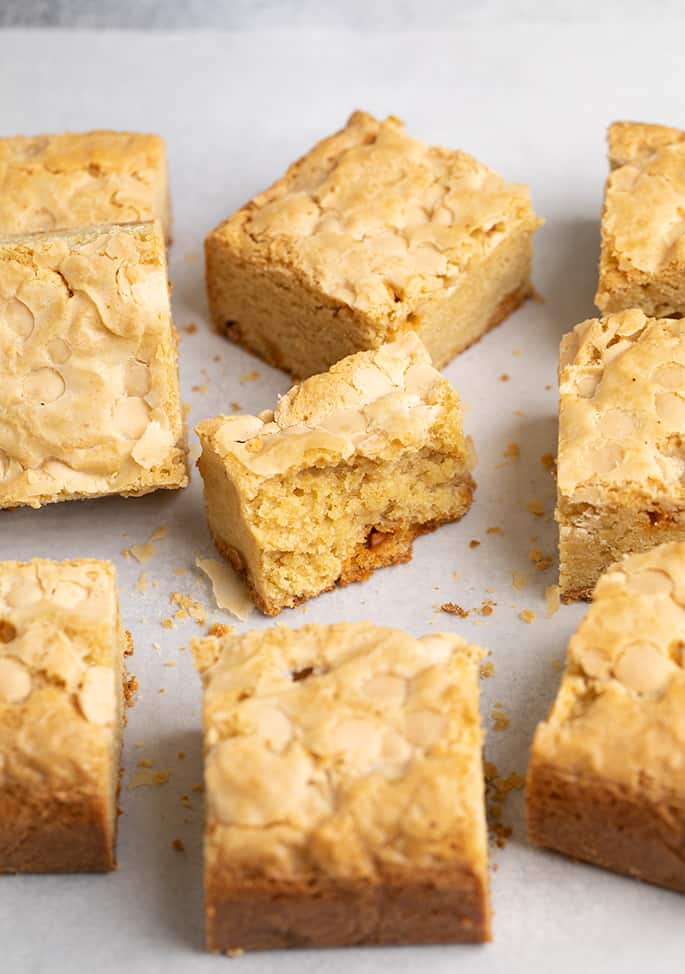 Cut square blondies on white paper with one broken in half in the center