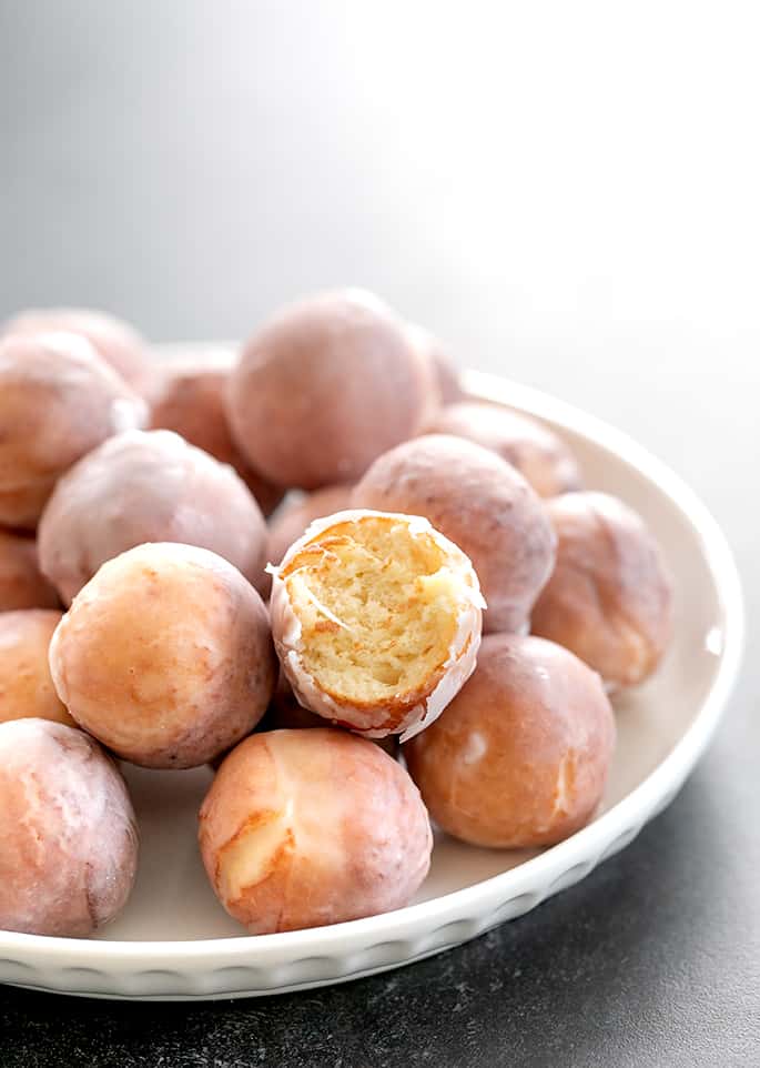 Donut holes being served with one bitten