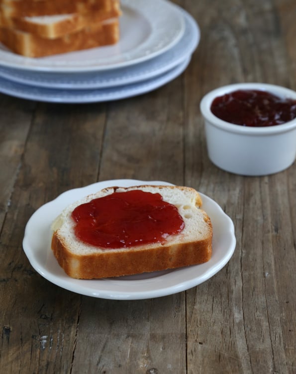 A close up of a Alice of bread with jam on white plate 