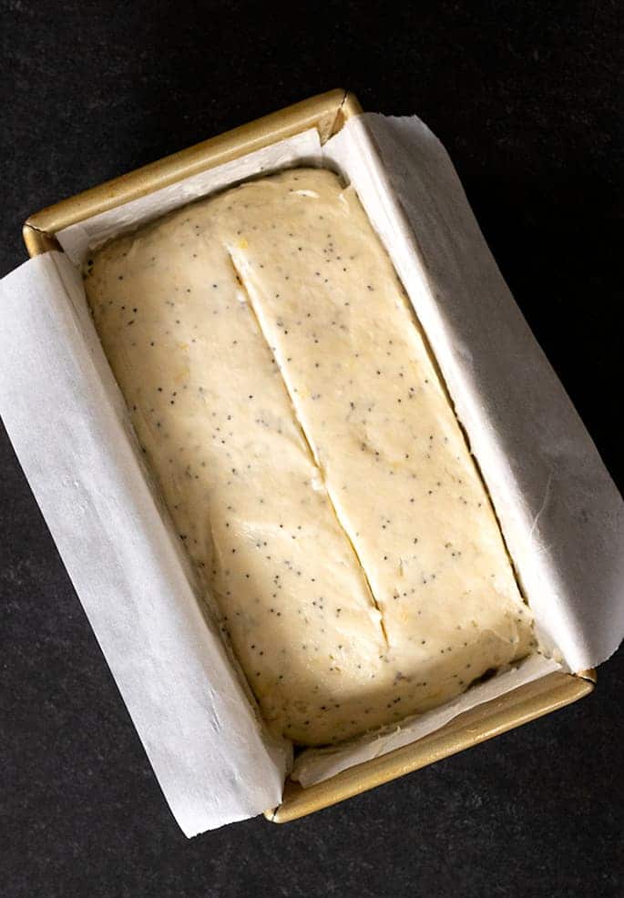 Gluten free lemon poppyseed bread shown raw in a loaf pan from overhead.