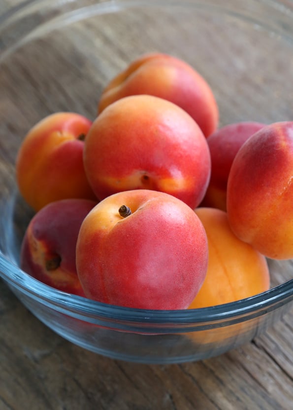 A bowl of apricots on a table