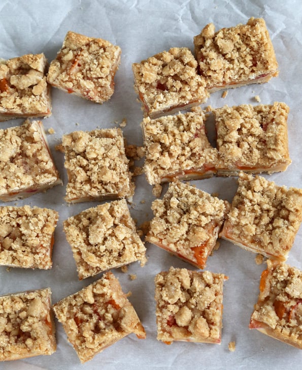 Overhead view of apricot crumble bars on a white surface 