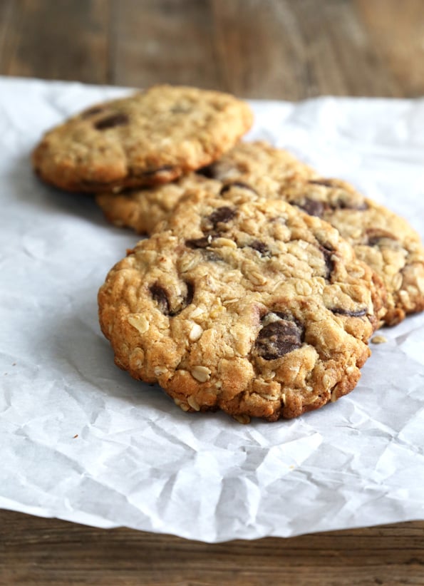 Oatmeal Chocolate Chip Cookies leaning against each there on white surface 